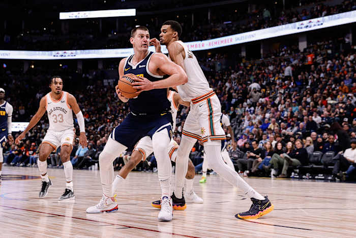 Denver Nuggets center Nikola Jokic (15) controls the ball as San Antonio Spurs center Victor Wembanyama (1) guards in the second quarter at Ball Arena.